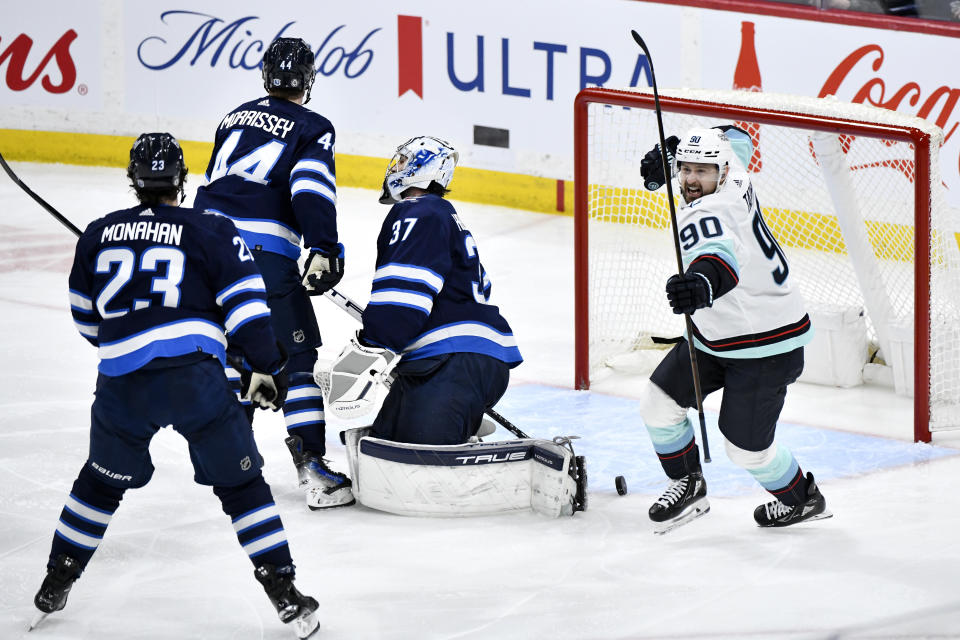 Seattle Kraken's Tomas Tatar (90) celebrates his goal against Winnipeg Jets goaltender Connor Hellebuyck (37) during the third period of an NHL hockey game Tuesday, March 5, 2024, in Winnipeg, Manitoba. (Fred Greenslade/The Canadian Press via AP)