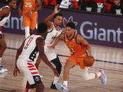 Phoenix Suns guard Devin Booker (1) drives to the basket against Washington Wizards guard Jerome Robinson (12) in the first half an NBA basketball game in Lake Buena Vista, Fla., Friday, July 31, 2020. (Kim Klement/Pool Photo via AP)