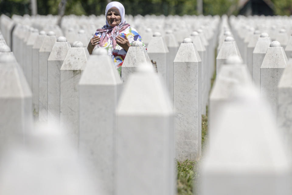 A woman prays at the memorial cemetery in Potocari, near Srebrenica, Bosnia, Friday, July 10, 2020. Nine newly found and identified men and boys will be laid to rest when Bosnians commemorate on Saturday 25 years since more than 8,000 Bosnian Muslims perished in 10 days of slaughter, after Srebrenica was overrun by Bosnian Serb forces during the closing months of the country's 1992-95 fratricidal war, in Europe's worst post-WWII massacre. (AP Photo/Kemal Softic)