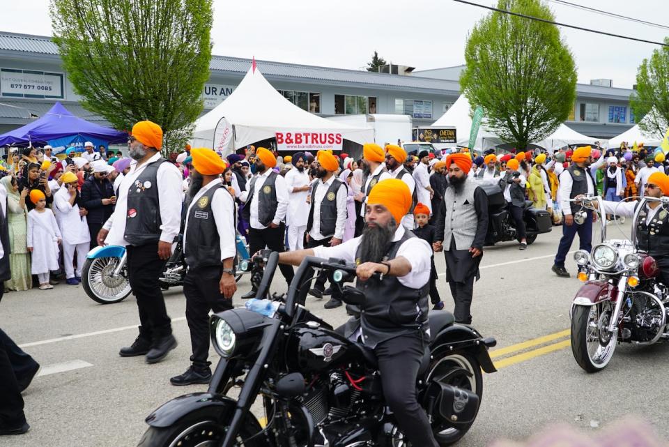 Members of the Sikh Motorcycle Club walk and ride in the Vaisakhi parade on Saturday.