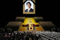 A portrait of former Japanese Prime Minister Shinzo Abe hangs on the stage during his state funeral, Tuesday, Sept. 27, 2022, Tokyo. Abe was assassinated in July. (Franck Robichon/Pool Photo via AP)