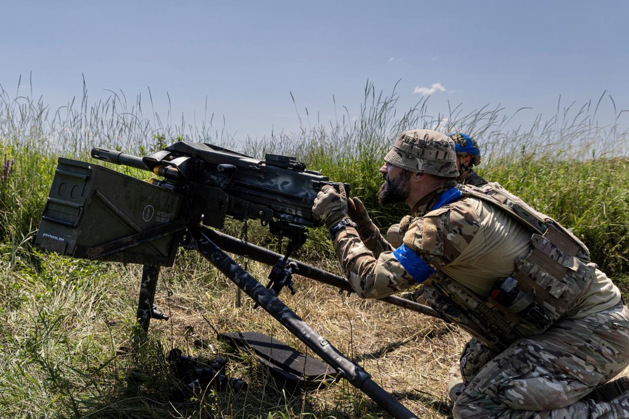 A Ukrainian serviceman aka Oduvanchik of the 3rd Assault Brigade fires a MK19 grenade launcher towards the Russian positions at the front line near Bakhmut (AP)