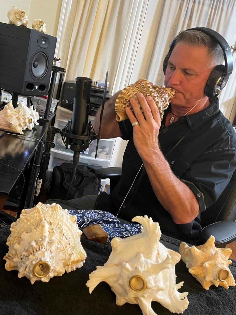 Don Chilton records himself playing the conch shells in his home studio. Chilton's music can be found on the final score of the film "Where the Crawdads Sing."