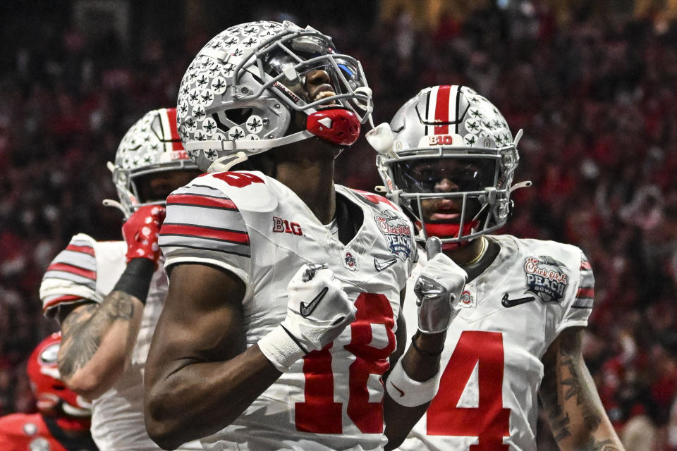 FILE - Ohio State wide receiver Marvin Harrison Jr. (18) celebrates his touchdown catch against Georgia during the first half of the Peach Bowl NCAA college football semifinal playoff game, Saturday, Dec. 31, 2022, in Atlanta. Ohio State is No. 3 in The Associated Press preseason Top 25 poll released Monday, Aug. 14, 2023. (AP Photo/Danny Karnik, File)