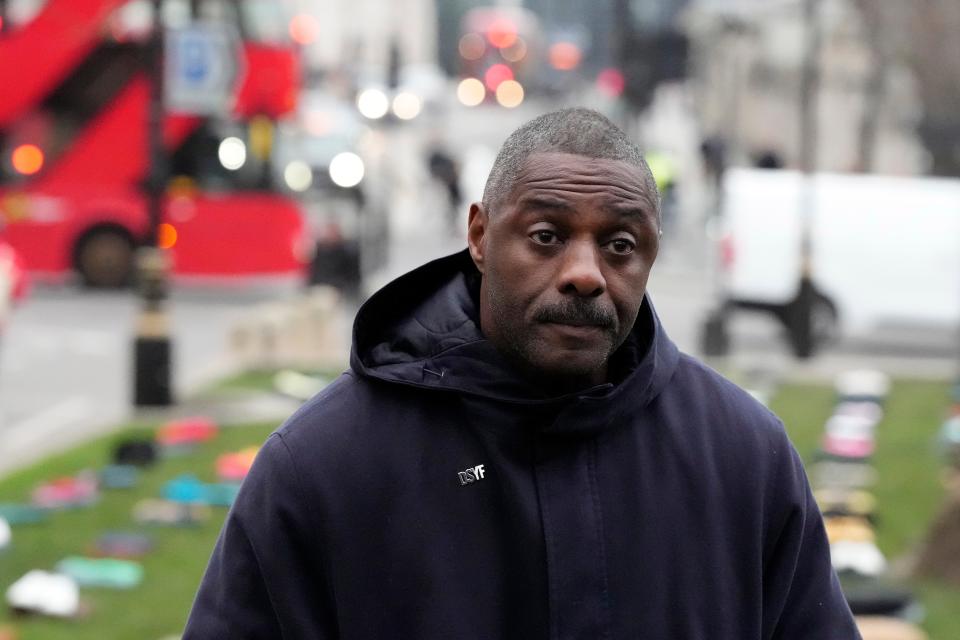 Idris Elba stands in Parliament Square with clothing representing the human cost of UK knife crime.