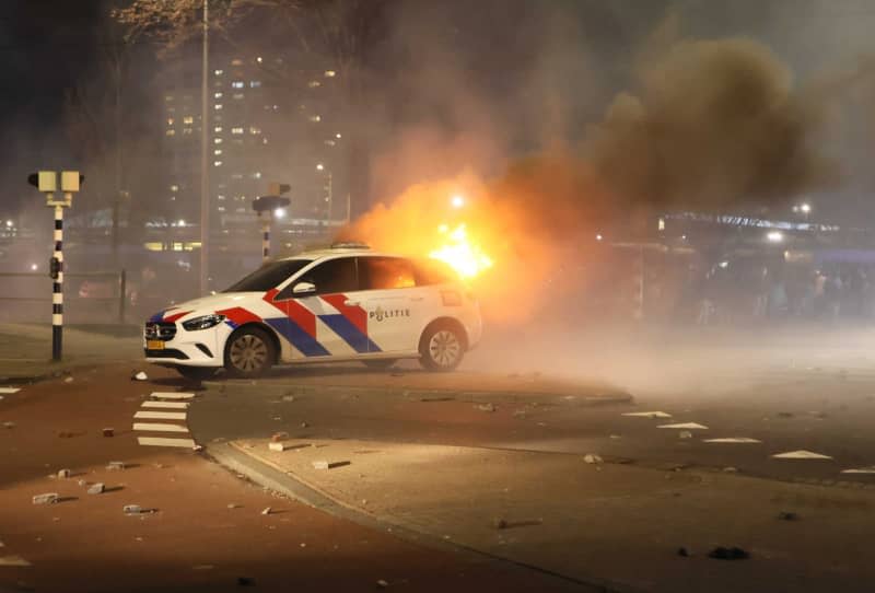 A burning police car in front of the opera house on Fruitweg following a confrontation between two groups of Eritreans after riots broke out following a meeting at the conference center. Wil Looijestijn/ANP/dpa