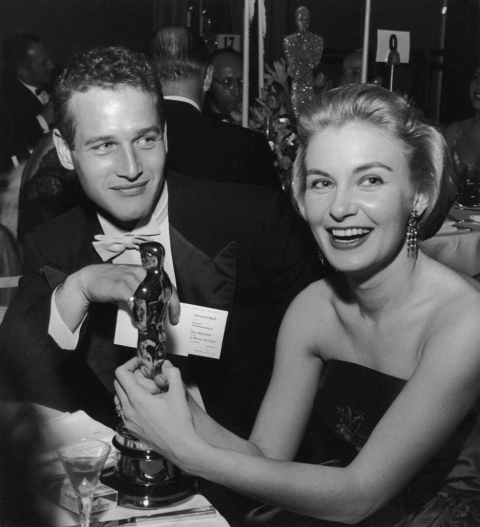 Joanne Woodward sostiene su estatuilla del Oscar mientras está sentada junto a su esposo, el actor estadounidense Paul Newman, durante el Governor's Ball, una fiesta de los Premios de la Academia celebrada en el Hotel Beverly Hilton, de Beverly Hills, California. En 1958 la actriz se consagró por su trabajo en Las tres caras de Eva