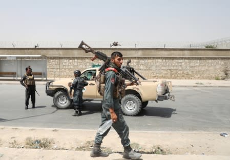 Members of Afghan security forces keep watch at the site of a car bomb blast in Kabul