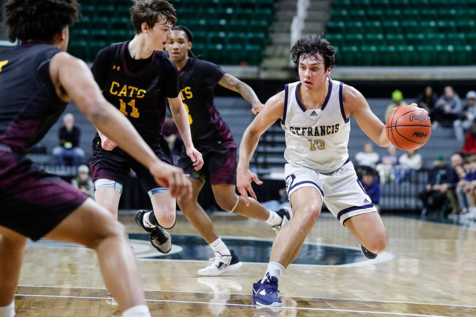 Traverse City St. Francis forward Joey Donahue (13) dribbles against Niles Brandywine guard Byron Linley (11) during the first half of MHSAA boys Division 3 semifinal at Breslin Center in East Lansing on Thursday, March 23, 2023.