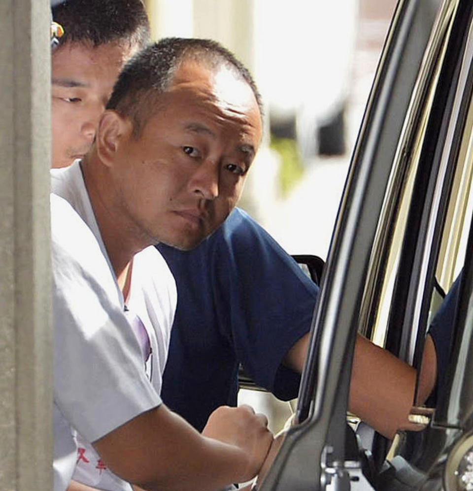 An activist is transferred before the forced repatriation to China at a police station, in Naha, Okinawa prefecture, southern Japan Friday, Aug. 17, 2012. Japan will deport 14 Chinese activists including the activist in the photo, Friday who were arrested for landing on disputed islands without authorization, relieving some of the tension from one of the territorial disputes Tokyo has with its neighbors. (AP Photo/Kyodo News) JAPAN OUT, MANDATORY CREDIT, NO LICENSING IN CHINA, HONG KONG, JAPAN, SOUTH KOREA AND FRANCE