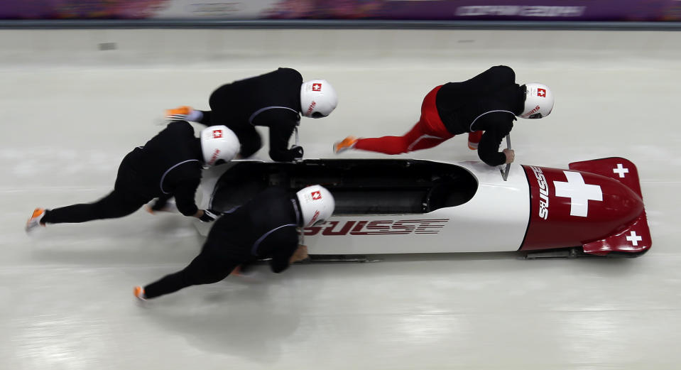 The team from Switzerland SUI-1, piloted by Beat Hefti, start a run during the men's four-man bobsled training at the 2014 Winter Olympics, Wednesday, Feb. 19, 2014, in Krasnaya Polyana, Russia. (AP Photo/Michael Sohn)