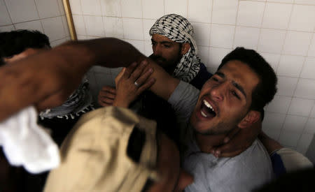 A colleague of Palestinian nurse Razan Al-Najar, who was killed during a protest at the Israel-Gaza border, reacts at a hospital in the southern Gaza Strip June 1, 2018. REUTERS/Ibraheem Abu Mustafa