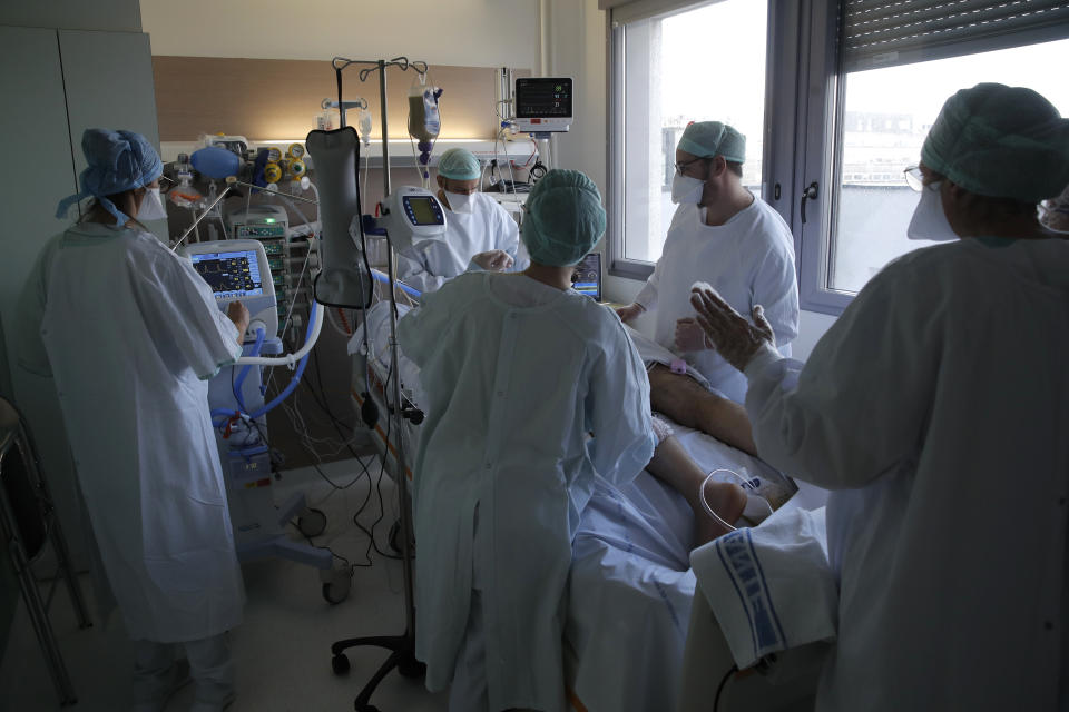 FILE - In this April 15, 2021, fie photo, medical staff tend to a patient affected by coronavirus in the ICU unit at the Charles Nicolle public hospital in Rouen, Normandy. Hospitals in many European countries are again under strain, treating increasingly younger patients with severe COVID-19 as older age groups benefit from the vaccinations. (AP Photo/Christophe Ena, File)