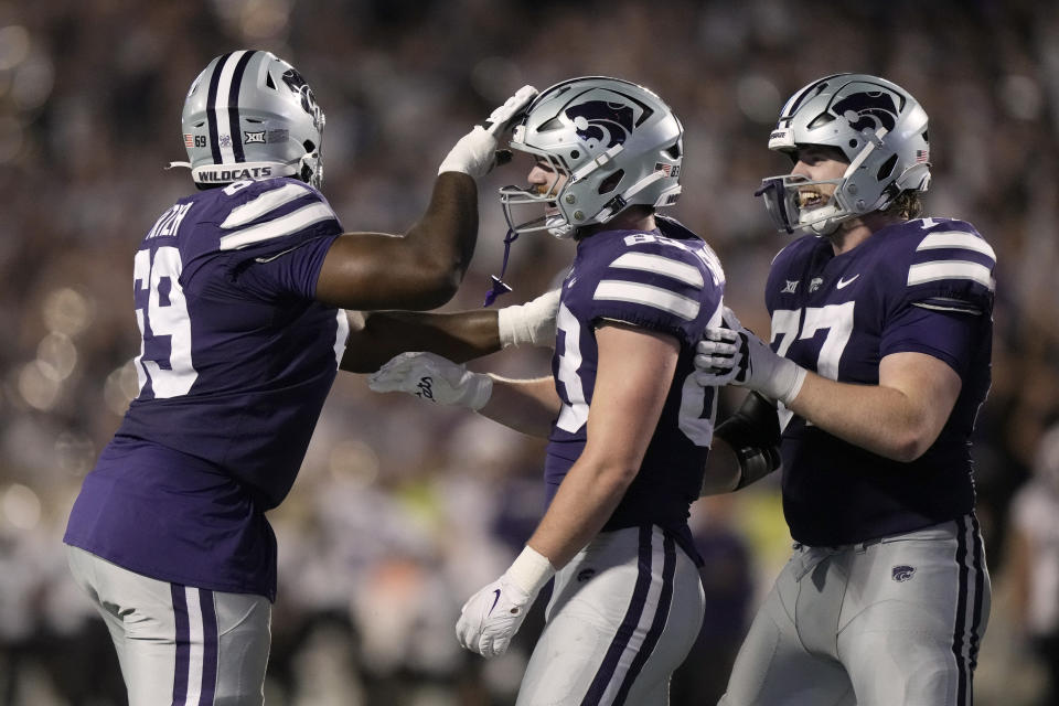 Kansas State tight end Will Swanson, center, celebrates with offensive linemen Taylor Poitier, left, and Carver Willis , right, after scoring a touchdown during the second half of an NCAA college football game against TCU Saturday, Oct. 21, 2023, in Manhattan, Kan. (AP Photo/Charlie Riedel)