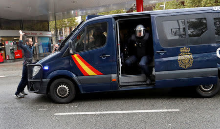 A demonstrator blocks a riot police van near a polling station for the banned independence referendum in Barcelona. REUTERS/Yves Herman