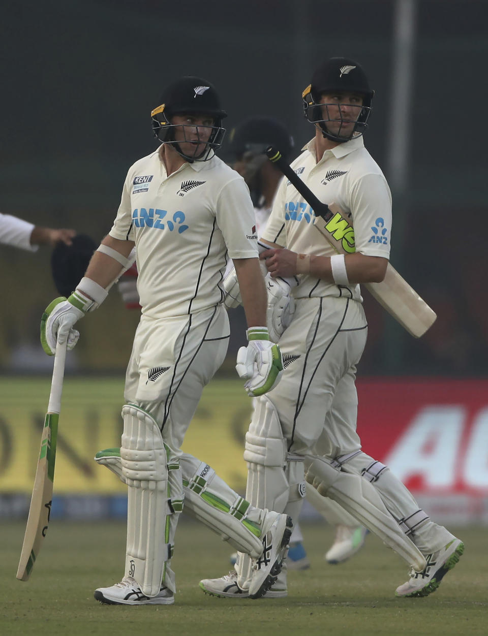 New Zealand's batsmen Tom Latham, left, and Will Young walk back to pavilion after the end of the play on day two of their first test cricket match with India in Kanpur, India, Friday, Nov. 26, 2021. (AP Photo/Altaf Qadri)