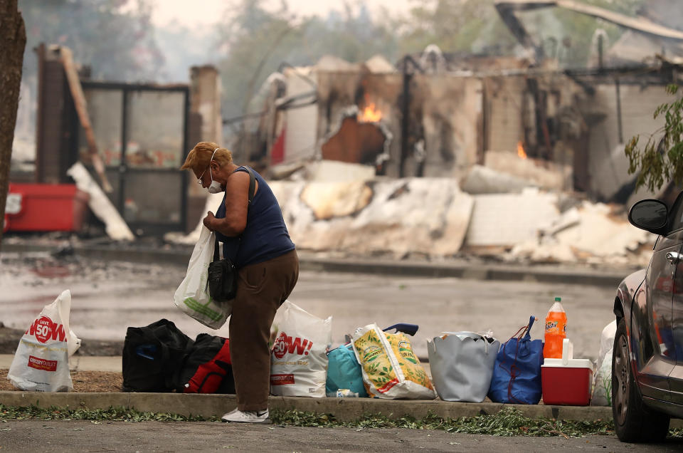 A resident goes through personal belongings in a parking lot in Santa Rosa.&nbsp;