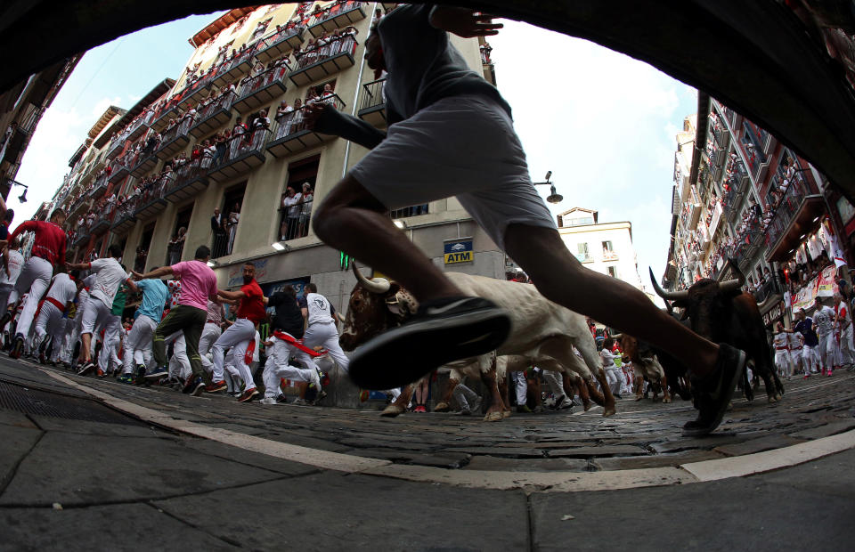 Revellers sprint in front of bulls and steers during the second running of the bulls at the San Fermin festival in Pamplona, Spain, July 8, 2019. (Photo: Jon Nazca/Reuters)