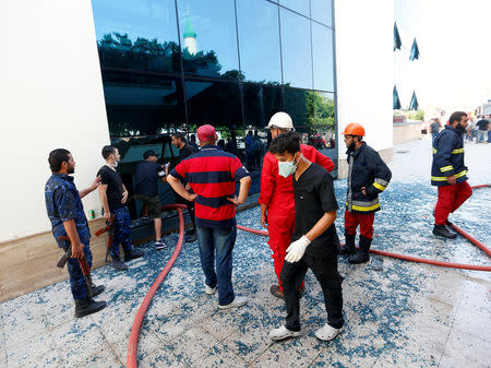 Firefighters and security personnel are seen at the headquarters of Libyan state oil firm National Oil Corporation (NOC) after three masked persons attacked it in Tripoli, Libya September 10, 2018. REUTERS/Ismail Zitouny