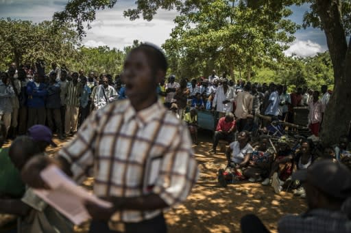 A volunteer reads a list of people who will receive food aid