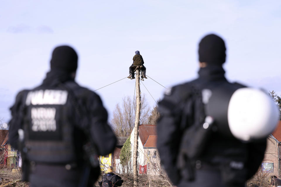 Two climate protection activists sit on a monopod on the edge of the village, ahead of the expected clearance of the lignite village of Luetzerath, Erkelenz, Germany, Saturday, Jan.7, 2023. (David Young/dpa via AP)