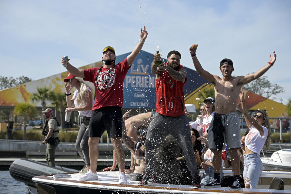 Tampa Bay Buccaneers NFL football tight end Tanner Hudson left, wide receiver Mike Evans, middle, and wide receiver Scott Miller celebrate their Super Bowl 55 victory over the Kansas City Chiefs with a boat parade in Tampa, Fla., Wednesday, Feb. 10, 2021. (AP Photo/Phelan Ebenhack)