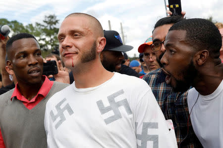 FILE PHOTO: A man walks with a bloody lip as demonstrators yell at him outside the location where Richard Spencer, an avowed white nationalist and spokesperson for the so-called alt-right movement, is delivering a speech on the campus of the University of Florida in Gainesville, Florida, U.S., October 19, 2017. REUTERS/Shannon Stapleton/File Photo