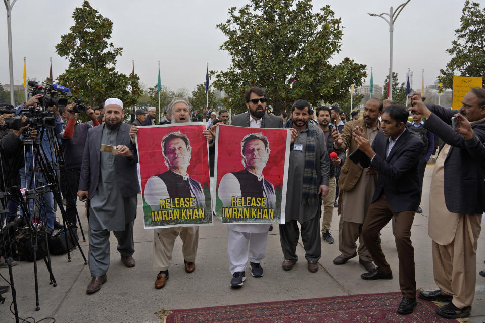 Pakistan's newly elected lawmakers displays a poster of their leader and imprisoned former Prime Minister Imran Khan as they arrive to attend opening session of the Parliament, in Islamabad, Pakistan, Thursday, Feb. 29, 2024. Pakistan's National Assembly swore in newly elected members on Thursday in a chaotic scene, as allies of jailed former Premier Khan protested what they claim was a rigged election. (AP Photo/Anjum Naveed)