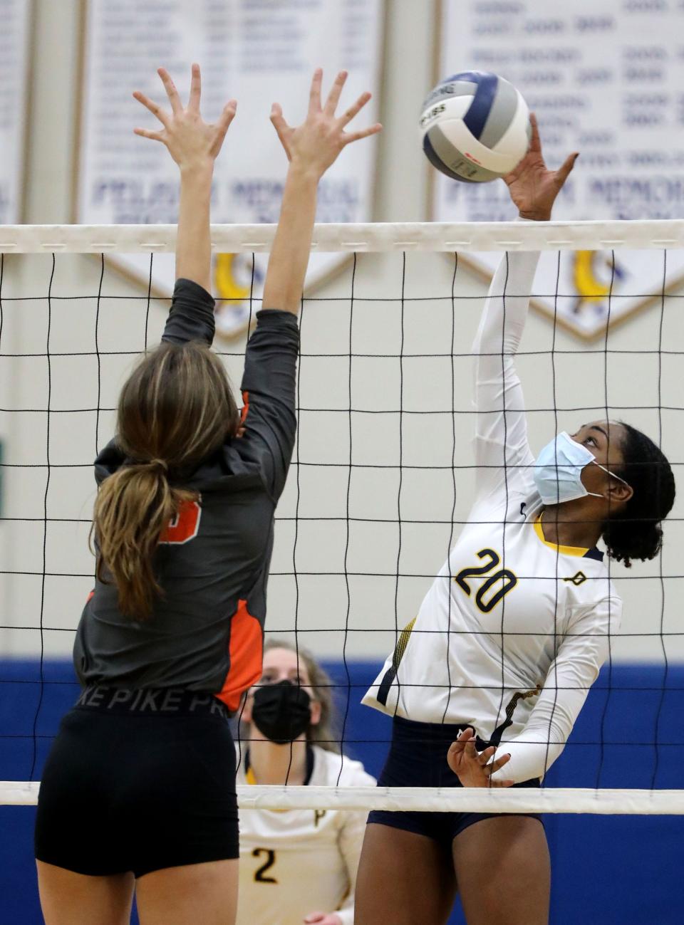 Pelham's Tiana Richardson returns a shot that Isabella Anvar of Mamaroneck tries to block during a varsity volleyball match at Pelham March 29, 2021. Pelham won the match in four sets: 20-25; 25-22; 25-19; 25-19.