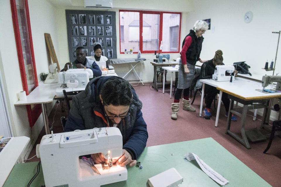 In this Monday, Jan. 30, 2017, a Syrian refugee participates in a sewing lesson, at a coat workshop of the Naomi NGO, in the northern Greek city of Thessaloniki. At the tiny workshop in this northern city, volunteers work long hours to try and keep the needy warm, with bursts of noise from sewing machines and a mission to turn discarded blankets into jackets, overcoats, and other winter wearables. (AP Photo/Giannis Papanikos)