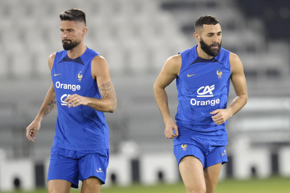 France's Olivier Giroud, left, and Karim Benzema run during a training session at the Jassim Bin Hamad stadium in Doha, Qatar, Saturday, Nov. 19, 2022. France will play their first match in the World Cup against Australia on Nov. 22. (AP Photo/Christophe Ena)