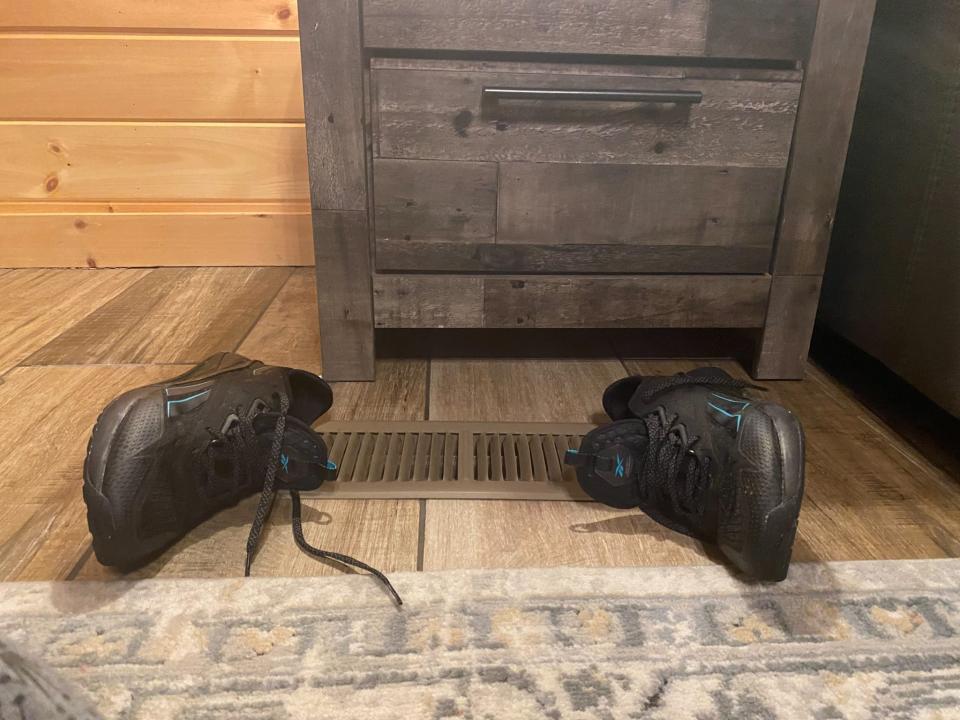 The author dries her shoes with a heat vent at an Airbnb.