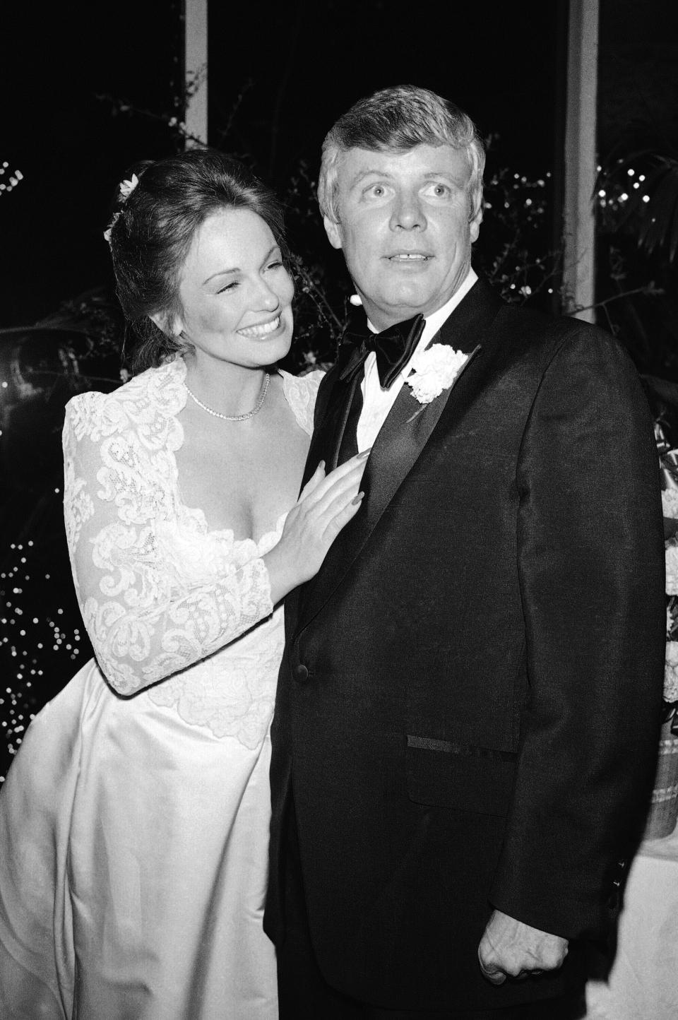 FILE - In this Saturday, March 17, 1979 file photo, The former Phyllis George and her new husband Boston Celtics owner John Y. Brown, Jr., pose for cameramen during reception at New York's Tavern on the Green. Phyllis George, the former Miss America who became a female sportscasting pioneer on CBS's “The NFL Today” and served as the first lady of Kentucky, has died. She was 70. A family spokeswoman said George died Thursday, May 14, 2020, at a Lexington hospital after a long fight with a blood disorder. (AP Photo/ G. Paul Burnett, File)