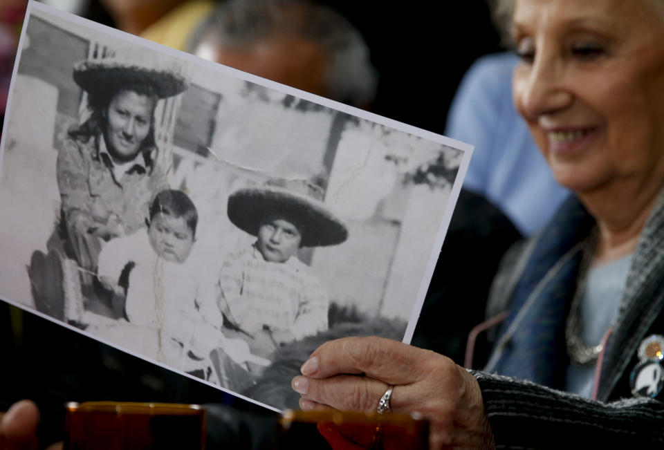 President of the Grandmothers of Plaza de Mayo human rights group, Estela de Carlotto, holds a photo of Rosario del Carmen Ramos, with two of her three sons Ismael, right, and Camilo, before she disappeared during Argentina's military dictatorship, in Buenos Aires, Argentina Friday, Aug. 3, 2018. The human rights group announced they found Rosario's other son Marcos Eduardo Ramos, who was kidnapped together with his brother Ismael in 1976 during the last military dictatorship in Argentina. (AP Photo/Natacha Pisarenko)