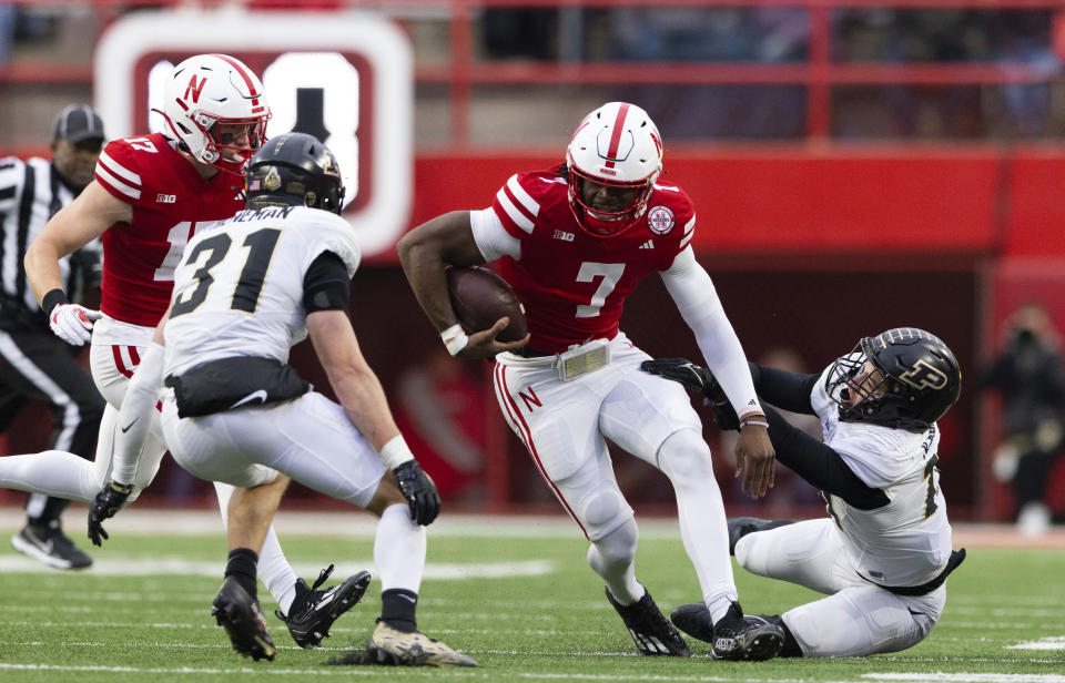 Nebraska quarterback Jeff Sims, center, carries the ball against Purdue's Dillon Thieneman, second left, and Yanni Karlaftis, right during the second half of an NCAA college football game Saturday, Oct. 28, 2023, in Lincoln, Neb. (AP Photo/Rebecca S. Gratz)