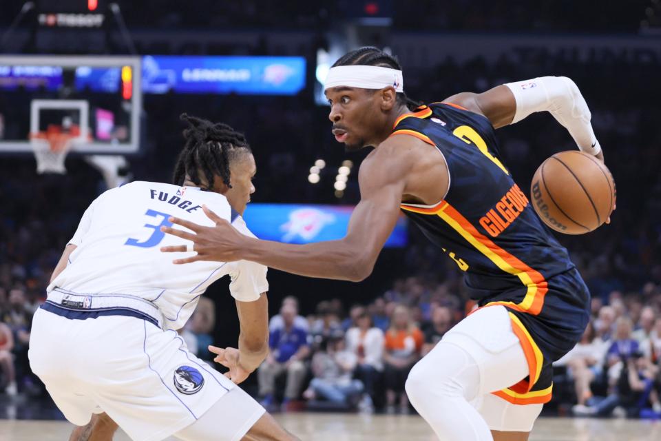 Thunder guard Shai Gilgeous-Alexander (2) goes past Mavericks forward Alex Fudge (3) during Sunday's game at Paycom Center.