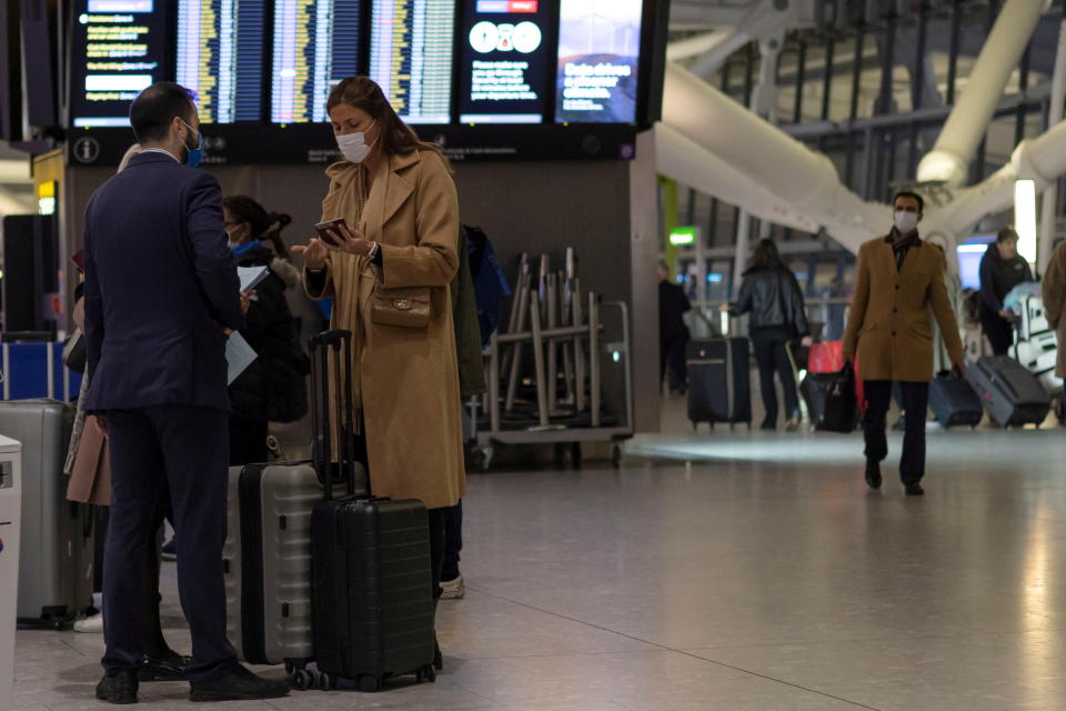 Heathrow A passenger talks with an employee as she checks-in on the American Airlines flight 101 between London and New York, following the lifting of restrictions on the entry of non-U.S. citizens imposed to help curb the spread of the coronavirus disease (COVID-19), at Heathrow International airport in London, Britain November 8, 2021. REUTERS/Carlos Barria