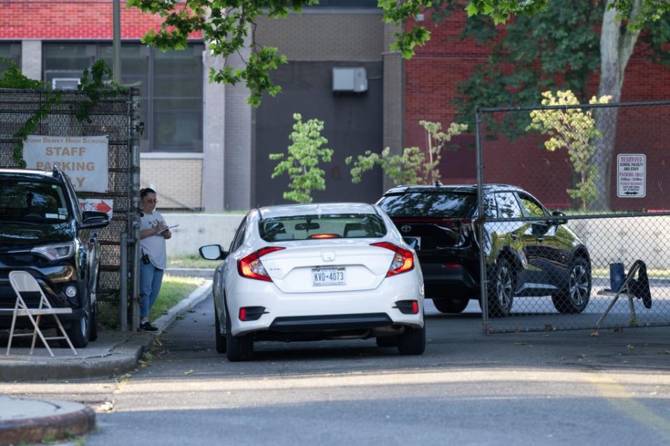 A John Dewey staffer guards the gate daily, checking permits and jotting down license numbers.