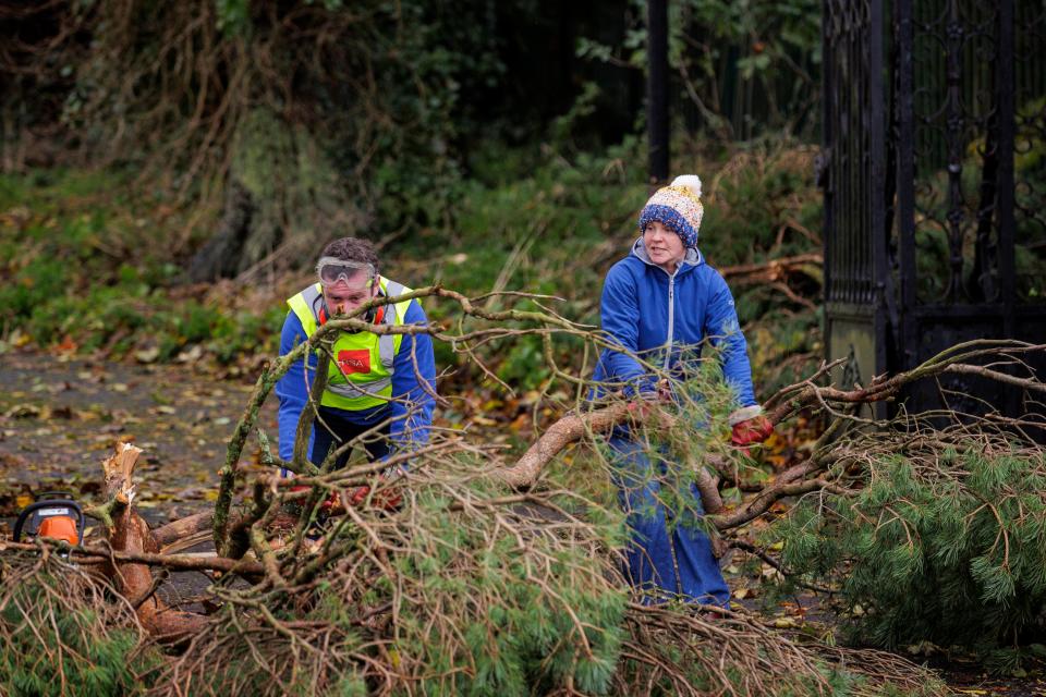 A man and a woman clear a fallen tree on the Dublin Road in Dundalk, Co Louth on Monday (Liam McBurney/PA Wire)