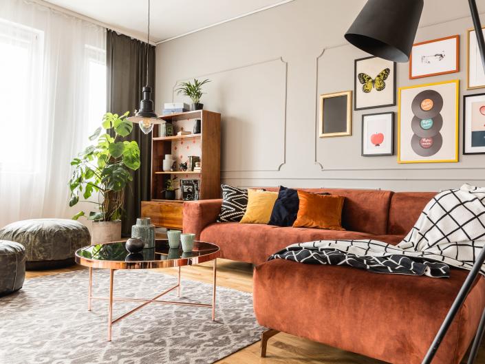 Rust sectional couch and gallery wall in cute living room