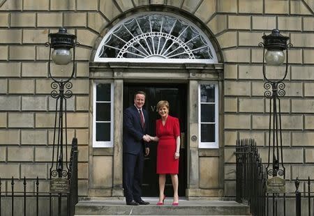 Scotland's First Minister Nicola Sturgeon (R), greets Britain's Prime Minister David Cameron, as he arrives for their meeting in Edinburgh, Scotland, Britain May 15, 2015. REUTERS/Russell Cheyne