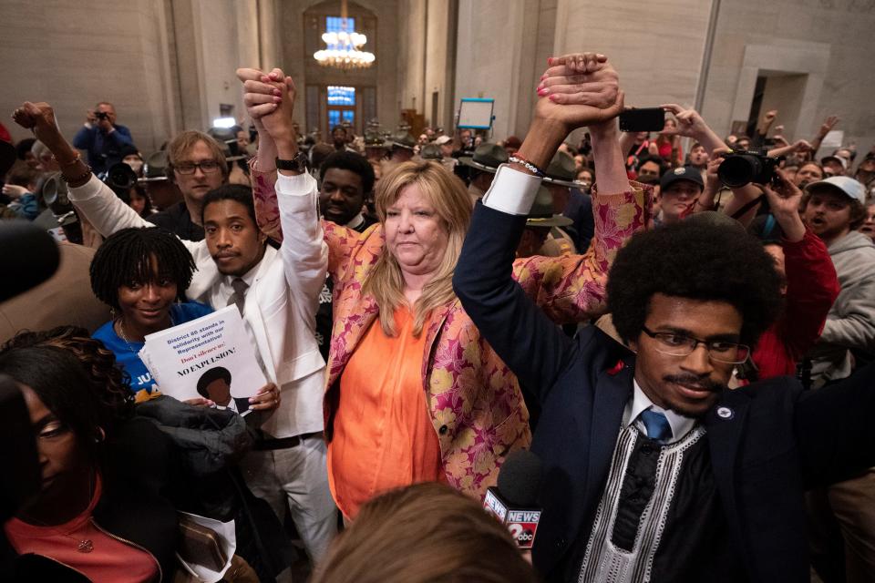 Rep. Justin Jones, in white, Rep. Gloria Johnson and Rep. Justin Pearson raise their hands outside the House chamber after Jones and Pearson were expelled from the legislature on April 6, 2023, in Nashville, Tenn.