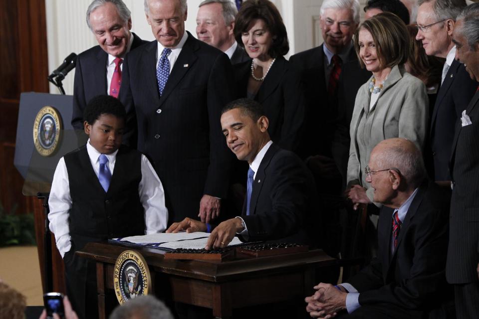 FILE - In this March 23, 2010, file photo, President Barack Obama reaches for a pen to sign the health care bill in the East Room of the White House in Washington. Several million American workers will cut back their hours on the job or leave the nation's workforce entirely because of Obama's health care overhaul, congressional analysts said Tuesday, Feb. 4, 2014, adding fresh fuel to the political fight over "Obamacare." (AP Photo/Charles Dharapak, File)