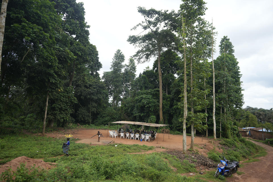 People gather at the Voodoo Oro sacred forest in Adjarra, Benin, on Wednesday, Oct. 4, 2023. As Benin’s population grows at nearly 3% a year, communities are trying to reconcile how to develop their land while preserving the forests. (AP Photo/Sunday Alamba)