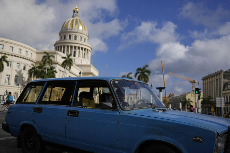 A driver navigates a vintage, Russian-made Lada station-wagon past the Capitol in Havana, Cuba, Friday, April 1, 2022. Global restrictions on transport and trade with Russia after its invasion of Ukraine pose a serious problem for Cubans because much of the island's fleets of trucks, buses, cars and tractors came from distant Russia and are now aging and in need of parts. (AP Photo/Ramon Espinosa)
