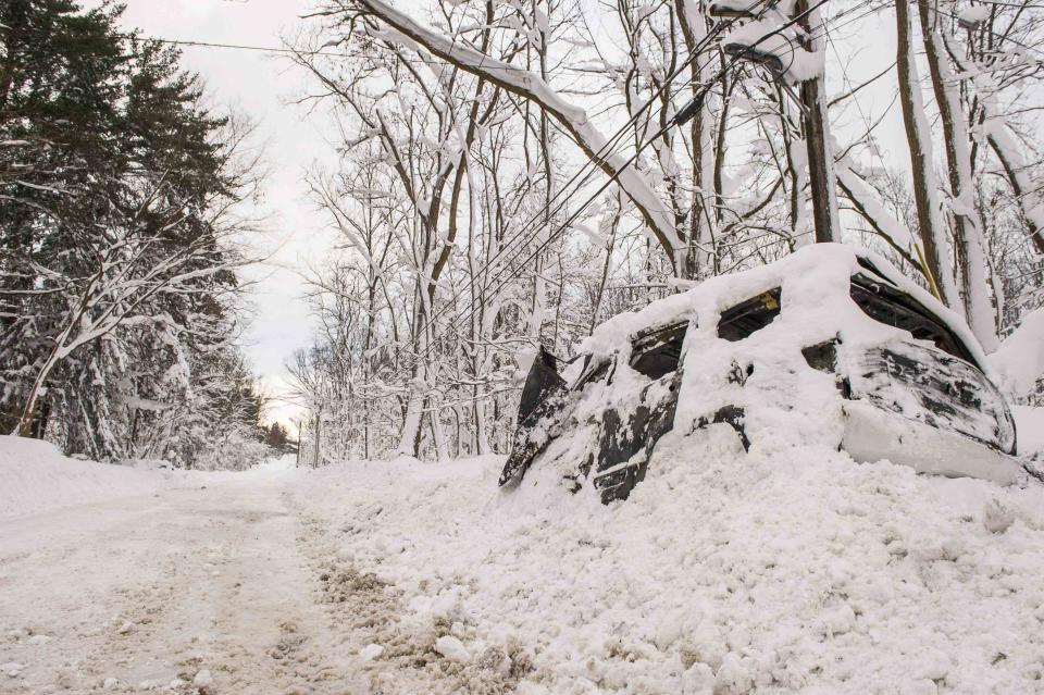 A vehicle sits abandoned in a snowbank in Buffalo