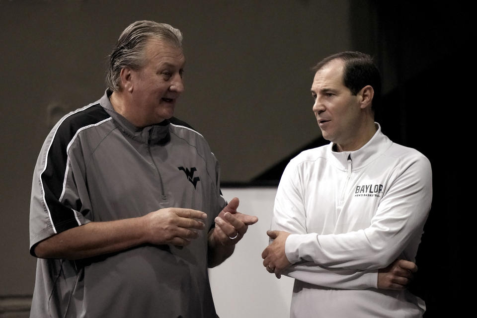 Baylor coach Scott Drew, right, and West Virginia coach Bob Huggins talk during Big 12 NCAA college basketball media day Wednesday, Oct. 20, 2021, in Kansas City, Mo. (AP Photo/Charlie Riedel)