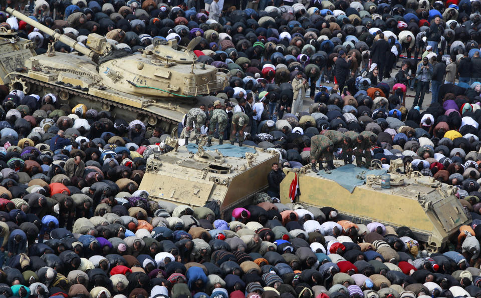 FILE - In this Feb. 11, 2011 file photo, anti-government protesters, and Egyptian soldiers on top of their vehicles, make traditional Muslim Friday prayers at the continuing demonstration in Tahrir Square in downtown Cairo, Egypt. As Egyptians mark the third anniversary of their revolution against autocrat Hosni Mubarak in the name of democracy, there has been a powerful sign of the country’s stunning reversals since: letters of despair by some of the prominent activists who helped lead the uprising, leaked from the prisons where they are now jailed. The letters show a daunted and broken spirit, no longer speaking of imminent democracy, but of injustices and a failed struggle.(AP Photo/Ben Curtis, File)