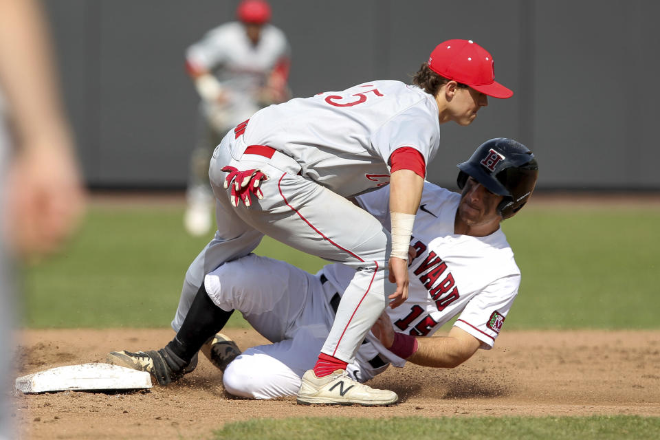 FILE - In this April 13, 2019, file photo, Harvard's Jake Suddleson, right, slides safely into second base ahead of the tag by Cornell's Matt Collins, left, during an NCAA college baseball game in Boston. The Ivy League has decided not to allow its spring-sport athletes who had their seasons shortened by the coronavirus pandemic to have an additional year of eligibility, despite the NCAA granting that option earlier this week. The move, which was announced Thursday, April 2, 2020, was consistent for the Ivy League, which hasn't allowed athletes who received medical redshirts to play for a fifth year.(AP Photo/Stew Milne, File)