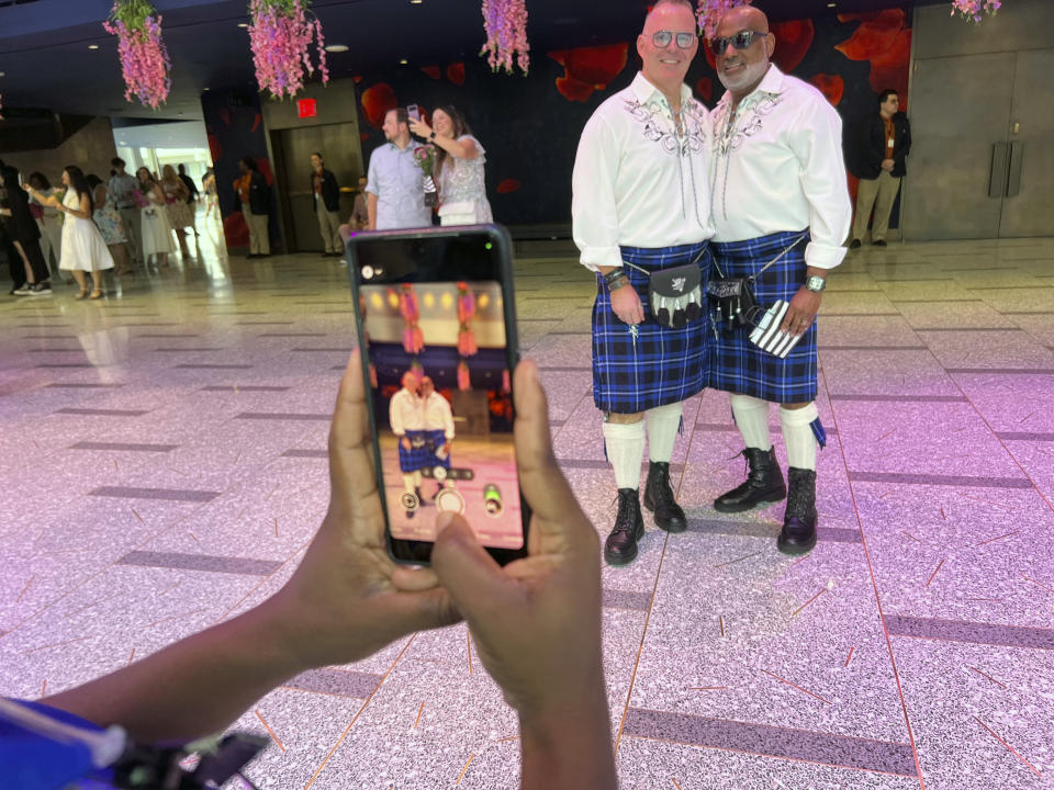 Archley Prudent, right, and his spouse of 12 years, Hugh, pose for a photo, Saturday, July 8, 2023, at New York's Lincoln Center. They were married as soon as gay marriage became legal in New York, but never had a proper wedding, so they joined 700 other couples for a mass wedding. (AP Photo/Bobby Caina Calvan)